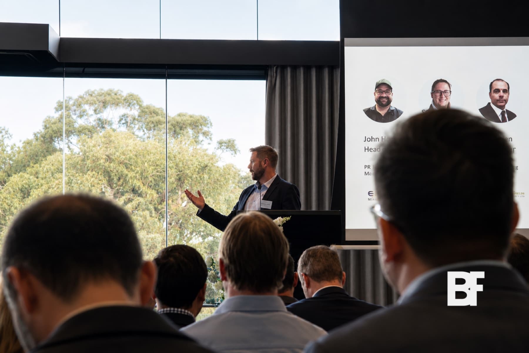Presenter speaking to a corporate audience in a bright event venue