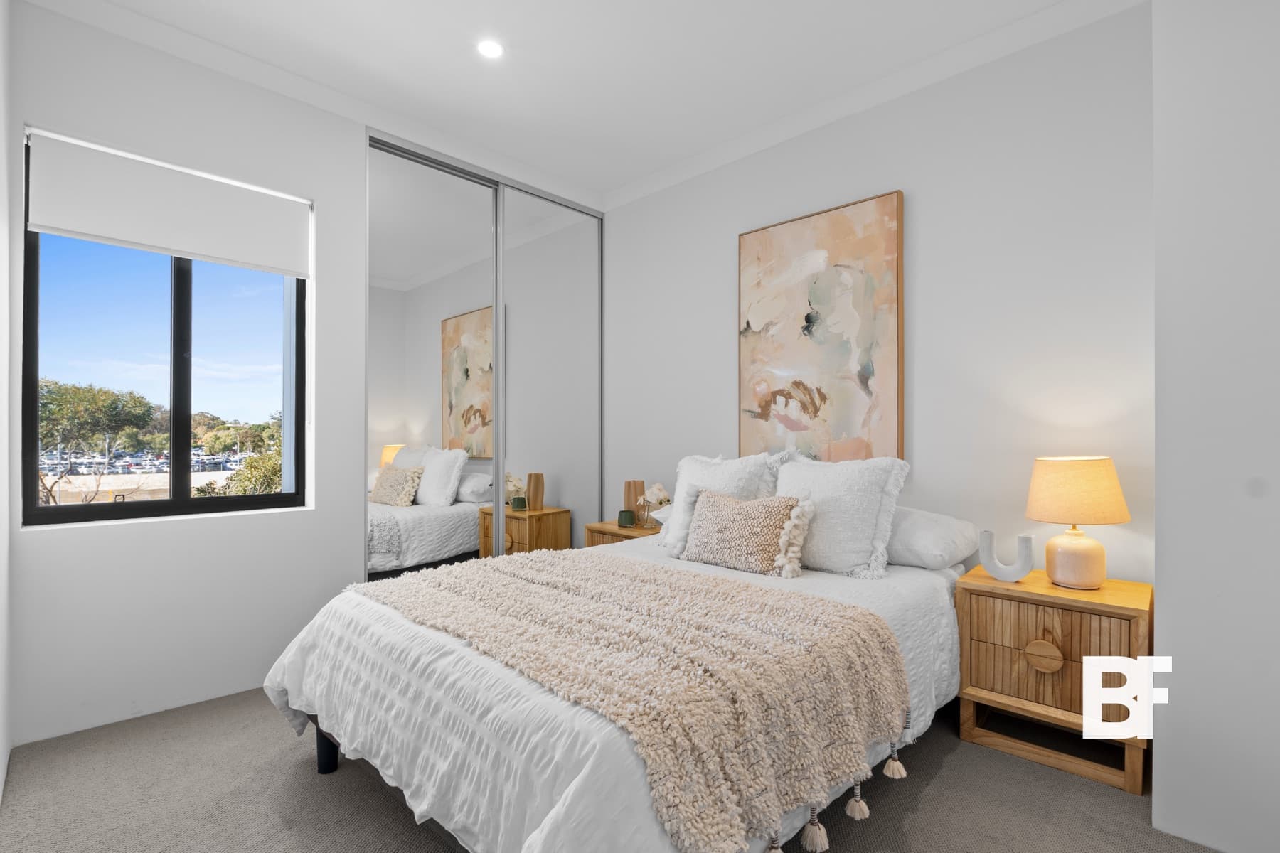 Wide bright bedroom with mirrored wardrobe photographed by BASEFORM